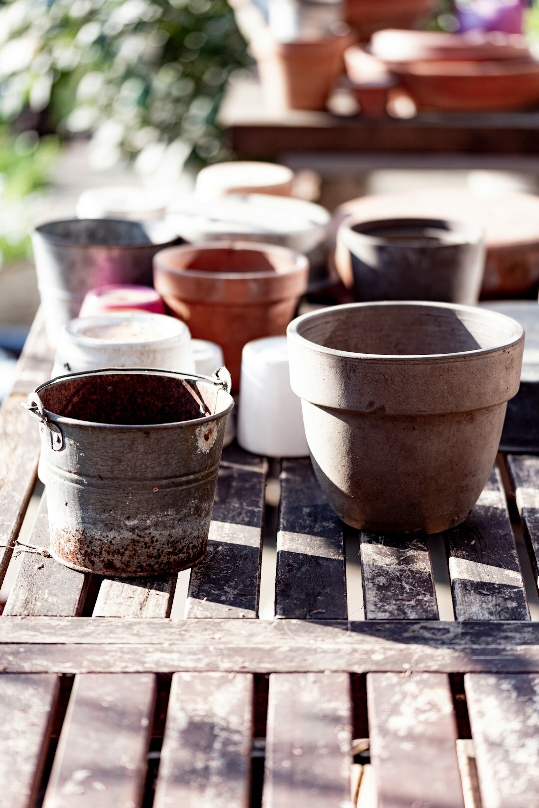 Potting soil, terracotta pots and gardening tools on a wooden table